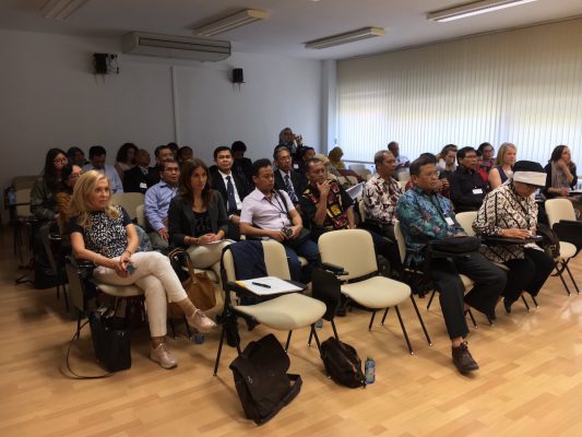 Se ve en el público personas de indonesia, Escocia, España y Grecia atendiendo a una conferencia