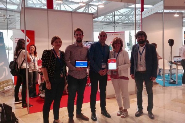 Foto de familia en el Stand Fundación Vodafone España donde ponentes y autoridades muestran tabletas con Ability Connect en el Congreso TIC y Turismo para todos de Málaga